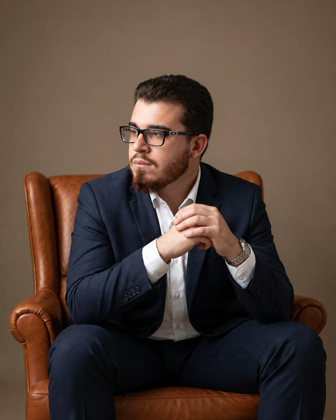 João Pedro Mansueli sentado em uma poltrona, em retrato profissional